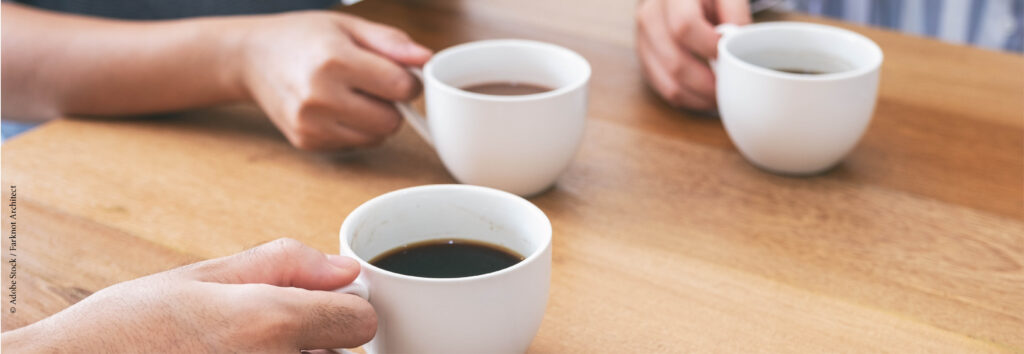 Trois mains tenant chacune une tasse de café
