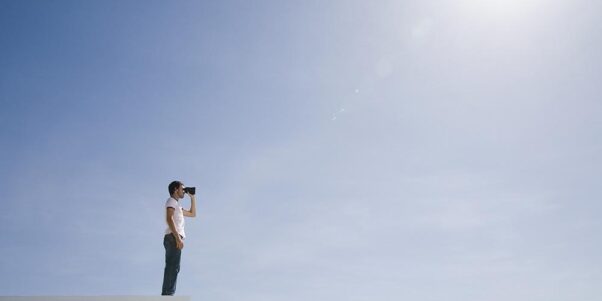 un jeune homme regardant l'horizon avec des jumelles