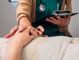 Médecin qui tient la main à son patient.
